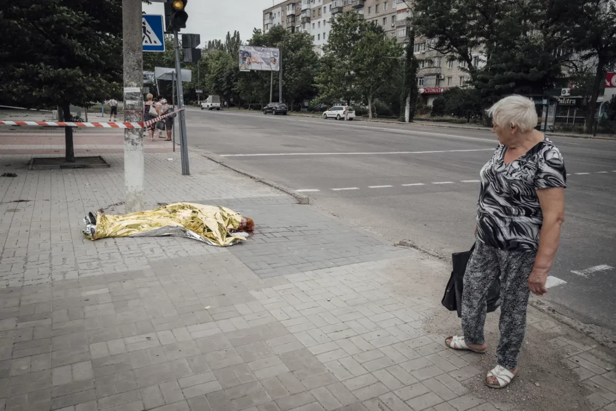 Mykolaïv, Ukraine, le 29 juillet 2022. Le corps d’une femme gît au sol. La victime a été touchée une heure plus tôt par une sous-munition russe. Photo © Adrien Vautier Mykolaïv, Ukraine, le 29 juillet 2022. Le corps d’une femme gît au sol. La victime a été touchée une heure plus tôt par une sous-munition russe. Photo © Adrien Vautier